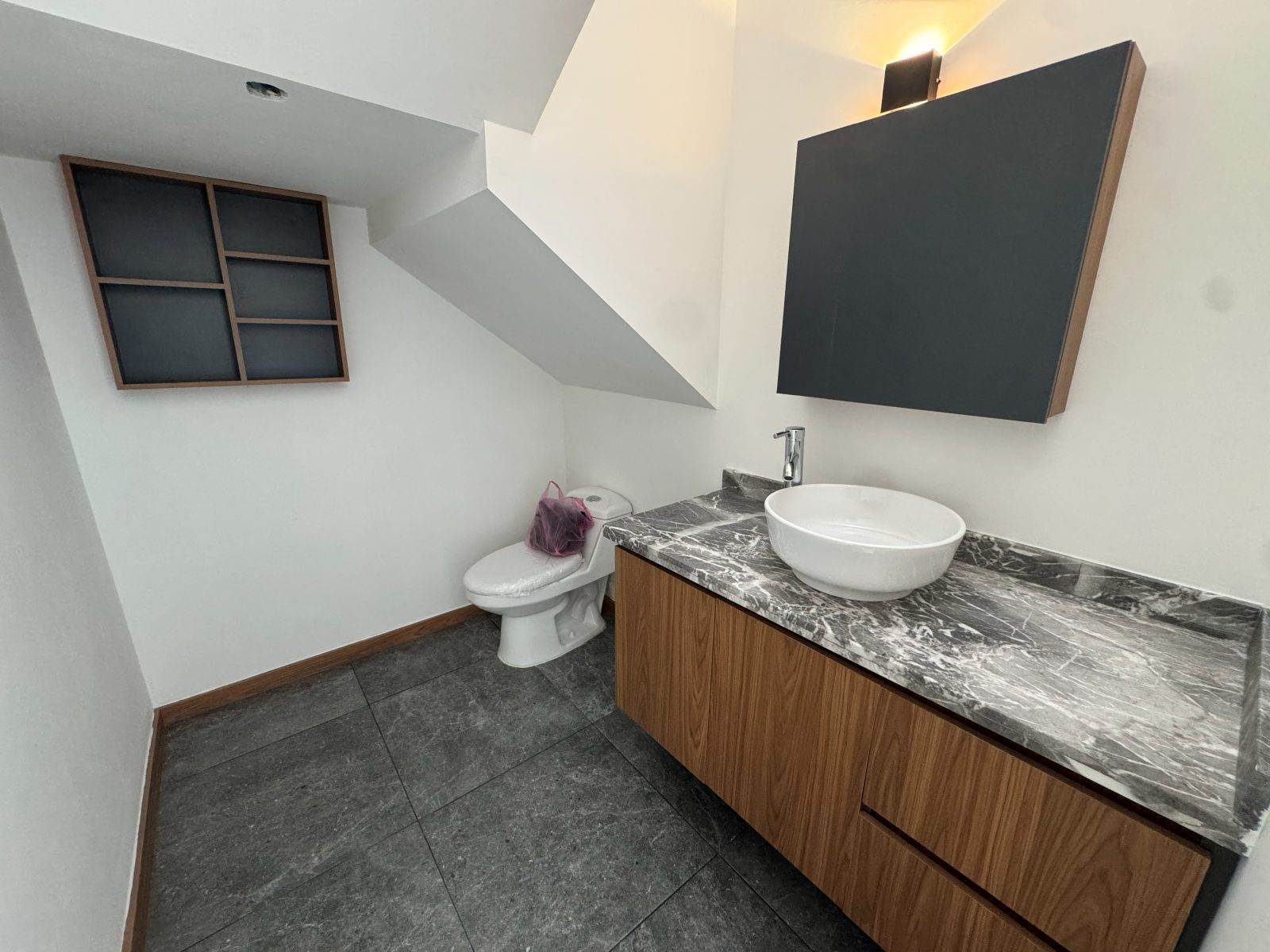 Baño con mueble flotante y cubierta de mármol