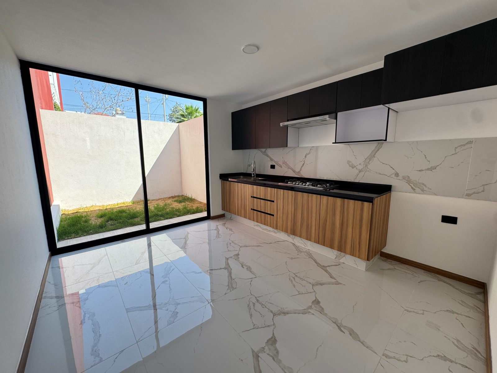 Cocina amplia con ventanal piso-a-techo al jardín
